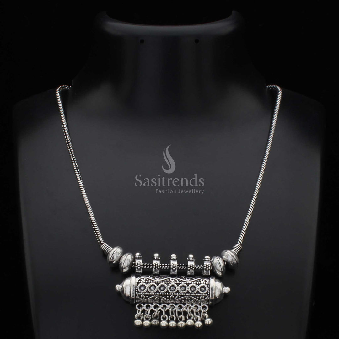 Traditional oxidised silver necklace with a cylindrical pendant and intricately carved antique ball drops – a cultural jewellery design rooted in tribal elegance, ideal for bohemian fashion and festive styling – Sasitrends
