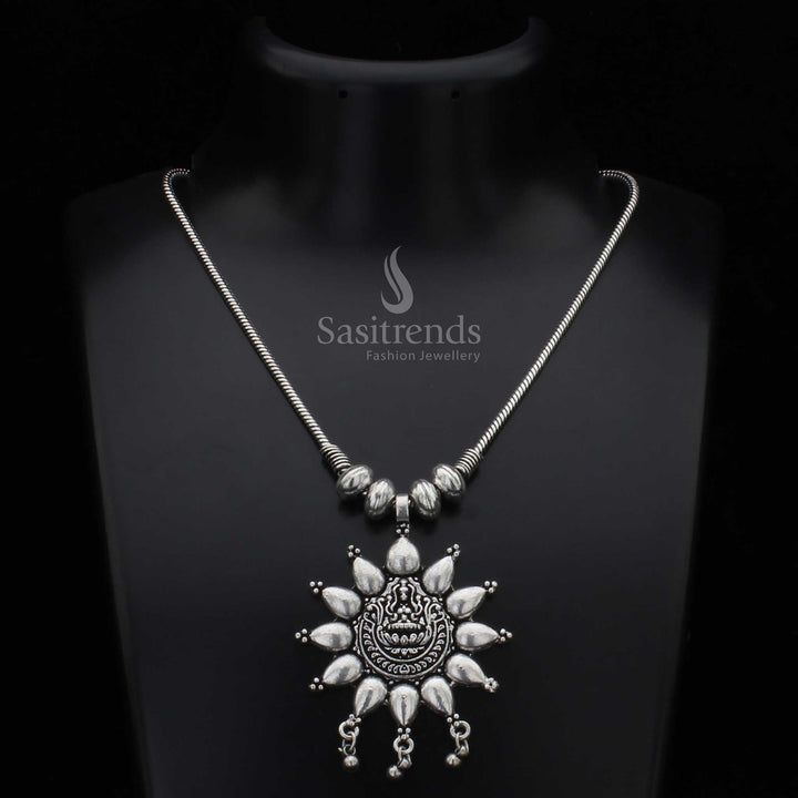 Majestic oxidised silver necklace showcasing an embossed divine deity and radiant floral sunburst carving – a sacred tribal jewellery design with antique artistry, perfect for festive temple occasions – Sasitrends