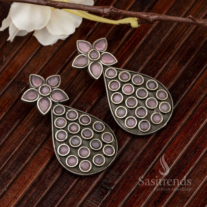 Delicate pear-shaped oxidised earrings with vibrant pink gemstone centre and dotted metal embossing – a graceful take on traditional handcrafted jewellery – Sasitrends