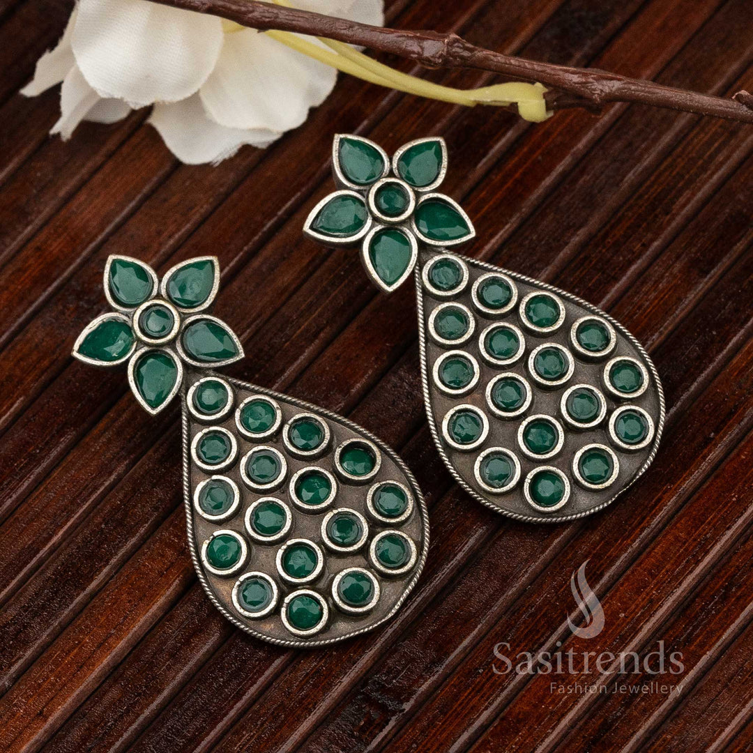 Traditional pear-shaped oxidised earrings with engraved green gemstone and leaf patterns, carrying temple-inspired divine jewellery artistry – Sasitrends