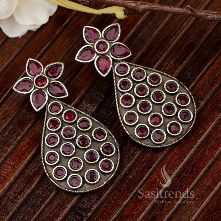 Regal oxidised earrings in pear shape with ruby gemstone centre and intricate metal artistry – inspired by Kemp stone celebration jewellery – Sasitrends