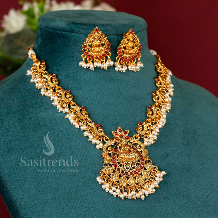 Grandiose matte gold-plated temple Lakshmi peacock necklace set, lavishly encrusted with ruby stones, radiating opulent mystic charm and timeless festive jewellery elegance - Sasitrends