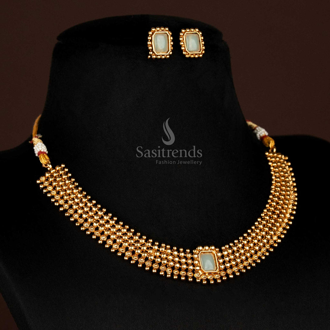 Soothing matte gold necklace with delicate ball chain and mint-coloured rectangle stone, accompanied by co-ordinated stud earrings – a traditional yet refreshing jewellery choice – Sasitrends