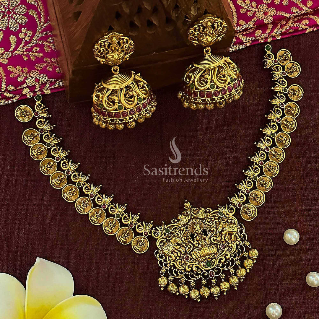 Temple matte gold plated bridal jewellery set with ruby-green stones featuring Lakshmi and peacock motifs, paired with handcrafted jhumkas for cultural ceremonies and graceful tradition – Sasitrends
