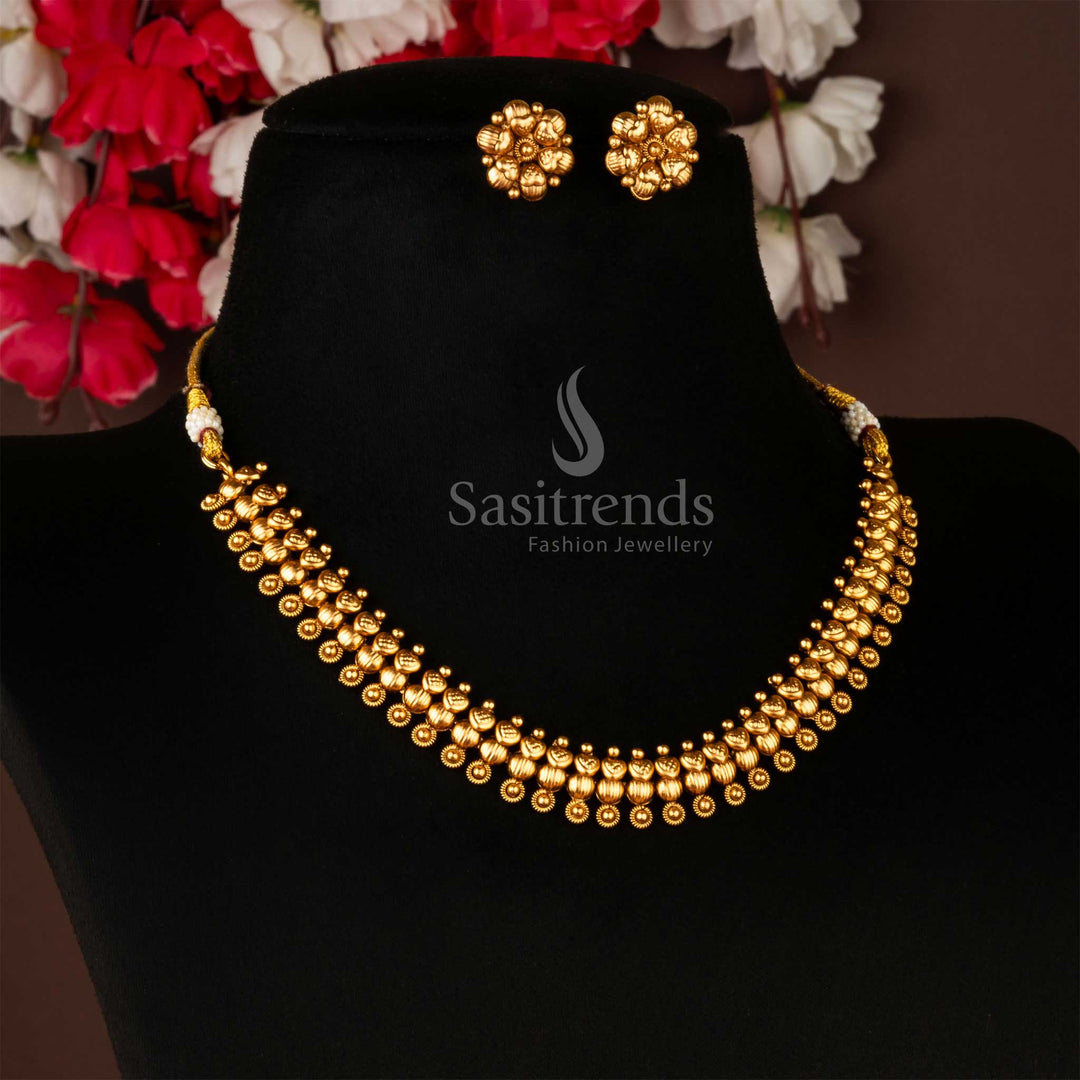 Traditional antique gold plated brass jewellery set with necklace and earrings against a dark background - Sasitrends