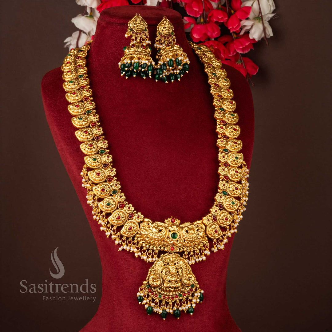 Exquisite temple-inspired long necklace jewellery set crafted in classic matte gold finish, featuring a divine Lakshmi pendant, antique detailing, and majestic jhumkas – a timeless piece for bridal ceremonies and festive cultural gatherings – Sasitrends