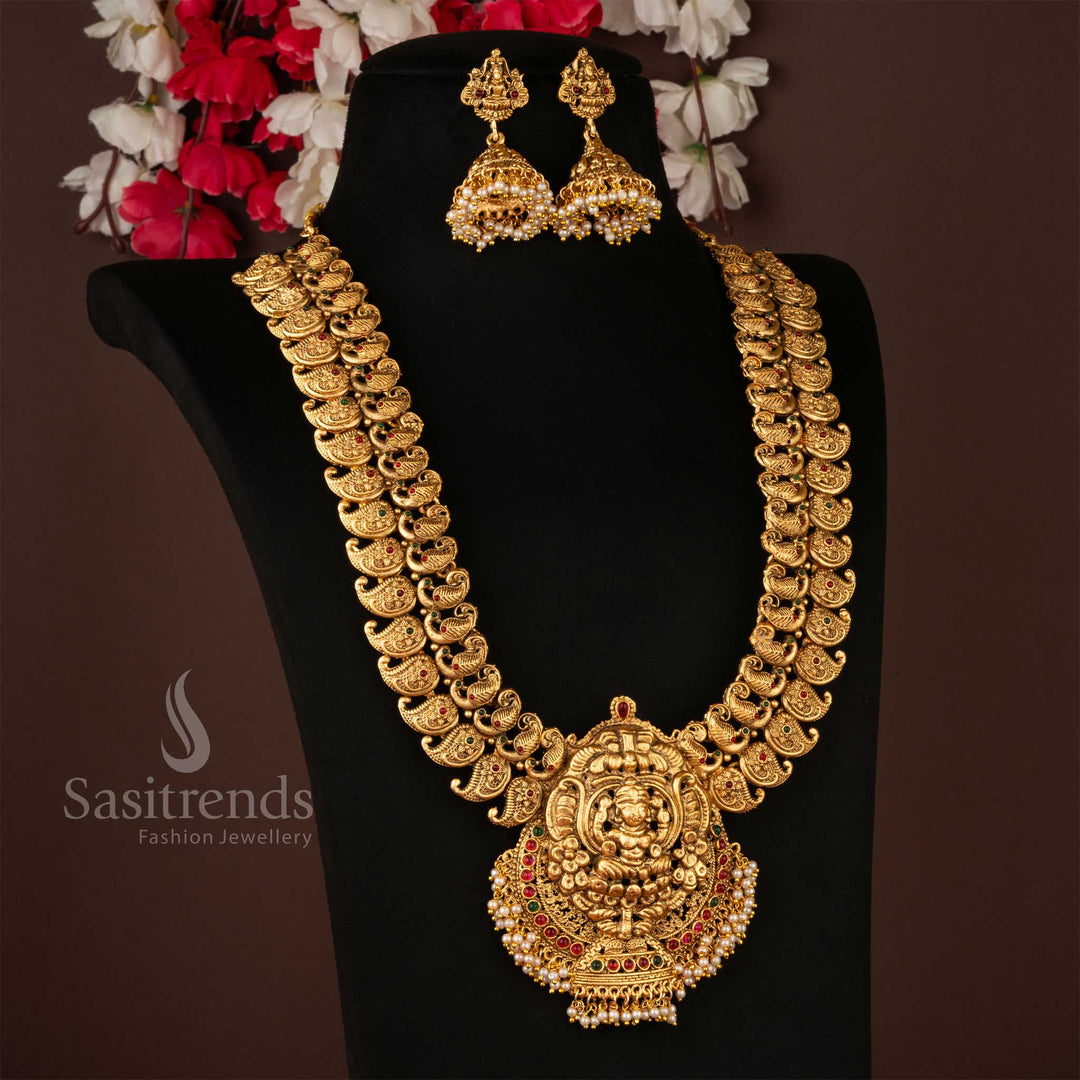 Intricately carved in temple heritage style, paired with grand antique jhumkas – an opulent adornment perfect for weddings and traditional celebrations – Sasitrends