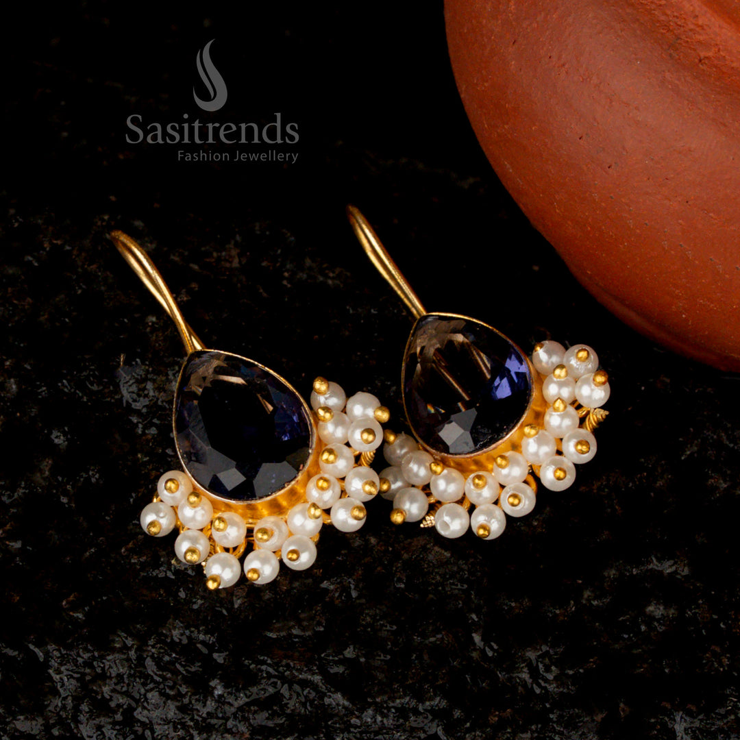 Lustrous violet Monalisa stone earrings in a pear-shaped design, elegantly finished with gold plating and pearl accents