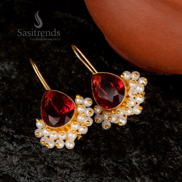 Fiery crimson Maroon red Monalisa stone earrings in a pear-shaped gold-plated design, enriched with pearl details for a bold statement