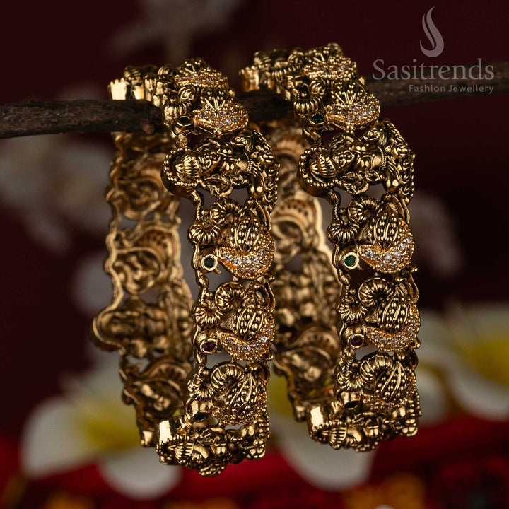 Bridal temple bangles adorned with sacred swan and Lakshmi motifs in a matte gold finish, beautifully enhanced by multi-colour AD stones – a radiant ethnic jewellery treasure by Sasitrends
