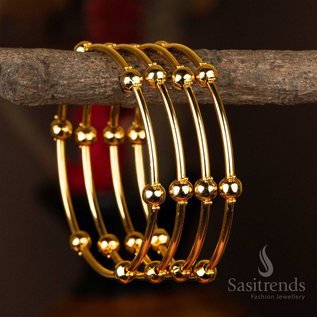 Set of four micro gold-plated kada bangles embellished with symmetrical golden orbs