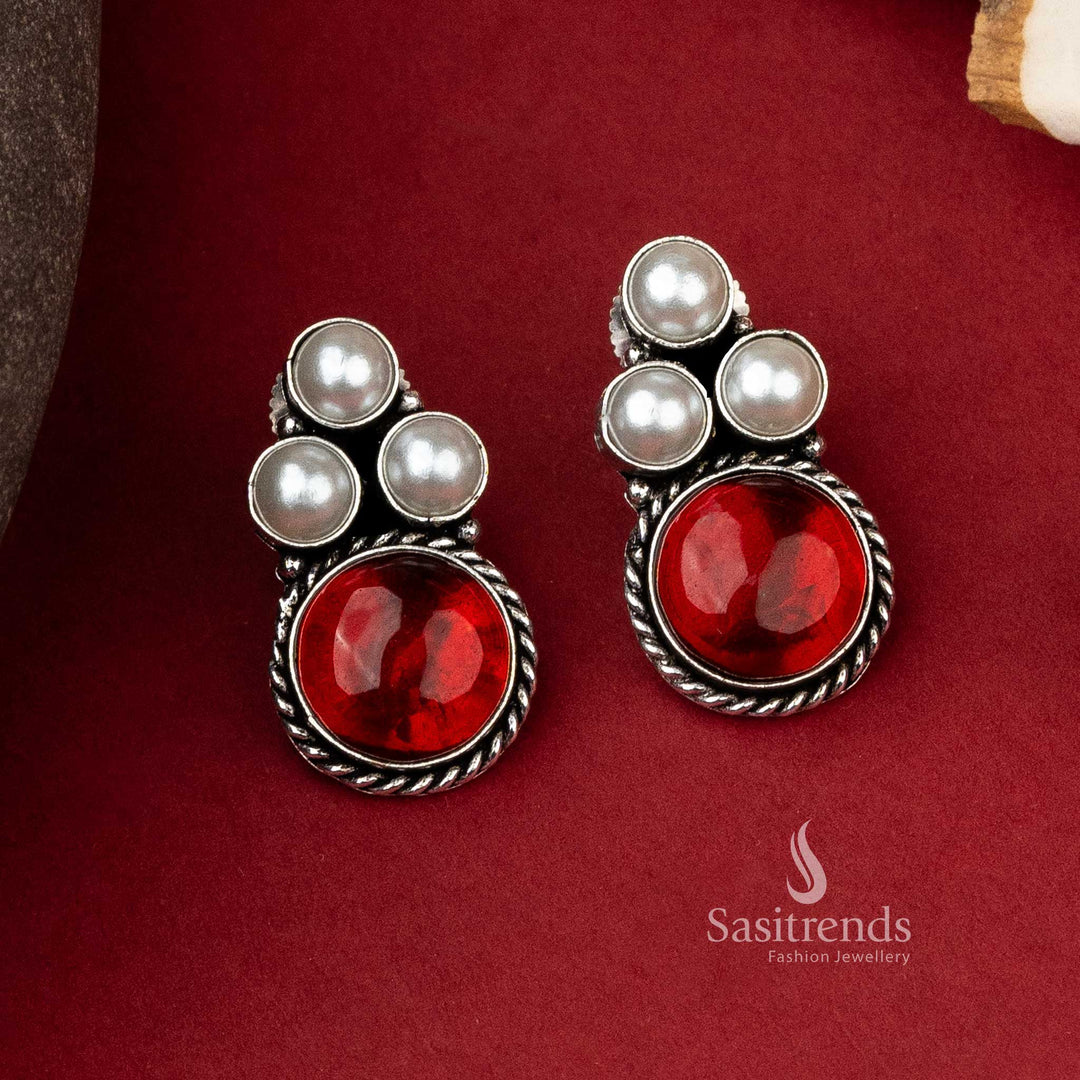 Stylish oxidized silver earrings featuring a trio of pearls with a bold red monalisa stone to accentuate any look