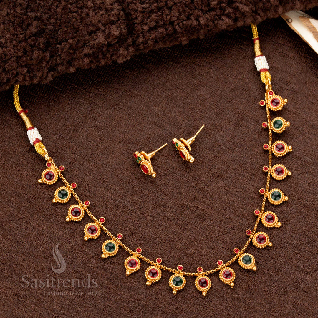 A stunning traditional matte gold temple necklace set with meticulously crafted round droplet motifs, adorned with a harmonious blend of ruby and green stones - Sasitrends