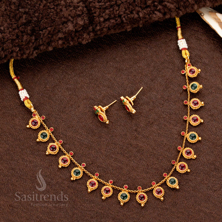A stunning traditional matte gold temple necklace set with meticulously crafted round droplet motifs, adorned with a harmonious blend of ruby and green stones - Sasitrends