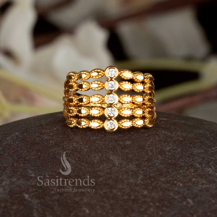 AD stone embellished micro plated gold ring in a step pattern.