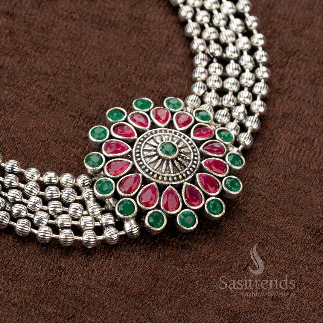 Festive oxidised German silver choker set with an enchanting floral pendant adorned with ruby and green stones, a striking choice for Navaratri, traditional attire, and grand occasions - Sasitrends