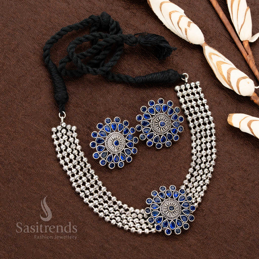 Traditional oxidised German silver choker set with a floral pendant enhanced by vibrant blue stones, making it a captivating accessory for Navaratri, festive occasions, and special gatherings - Sasitrends