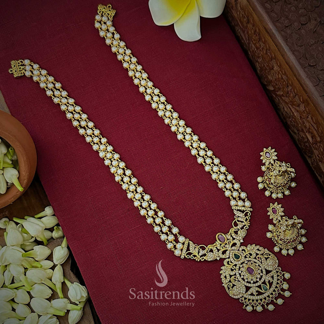 Regal matte gold tone bridal temple jewellery set featuring 3 layered pearl strands, intricate peacock motif floral pendant and matching jhumkas, ideal for opulent wedding attire and traditional grandeur – Sasitrends