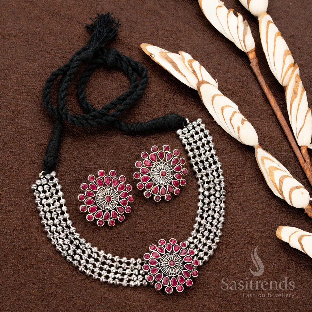 Handcrafted oxidised German silver choker set with a stunning floral pendant and rich ruby stones, styled with four-strand beads, ideal for Navaratri, weddings, and grand festive occasions - Sasitrends