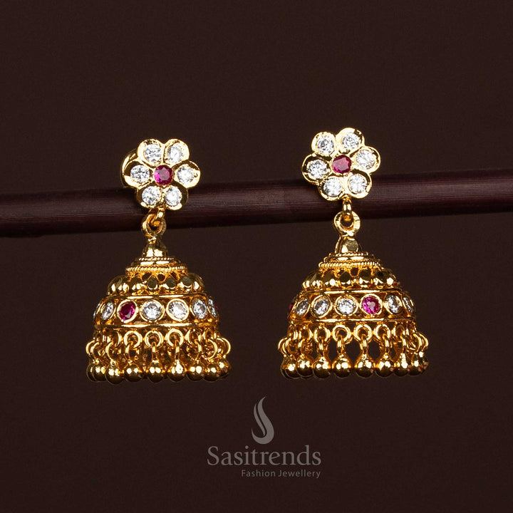 An exquisite expression of luxury, these Impon Addigai floral screw Jhumka earrings are crafted in a fine micro gold finish with ornate bell-shaped drops – a majestic blend of heritage design and artisanal finesse for grand festive styling – Sasitrends