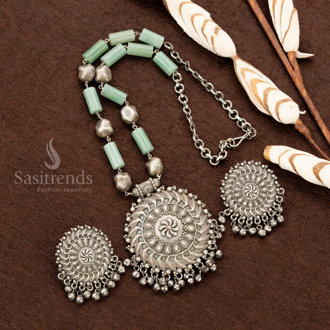Grand oxidised floral necklace, adorned with delicate mint stones, an ornate round pendant, and detailed matching earrings, embodying a vintage aesthetic, perfect Navaratri jewellery - Sasitrends