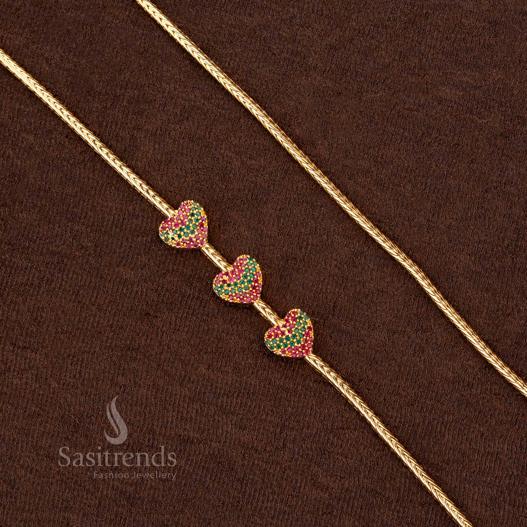 A premium one-gram gold plated trio heart mugappu chain with sparkling ruby-green stones, a must-have ethnic fashion accessory for any festive occasion - Sasitrends
