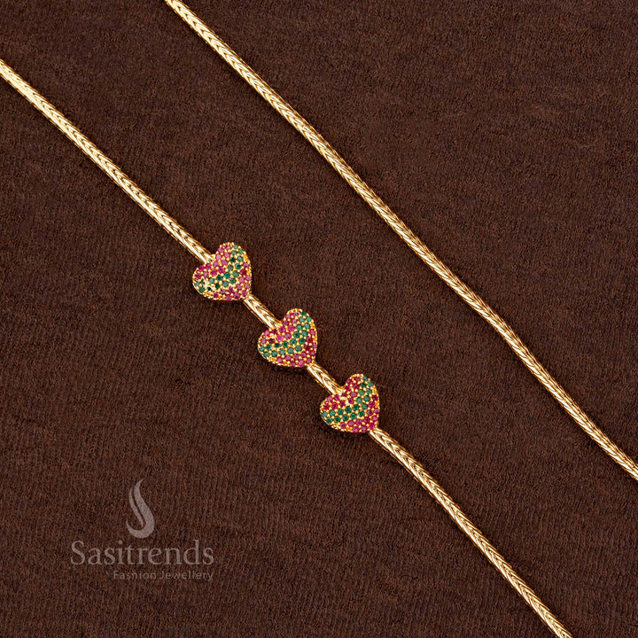 A premium one-gram gold plated trio heart mugappu chain with sparkling ruby-green stones, a must-have ethnic fashion accessory for any festive occasion - Sasitrends