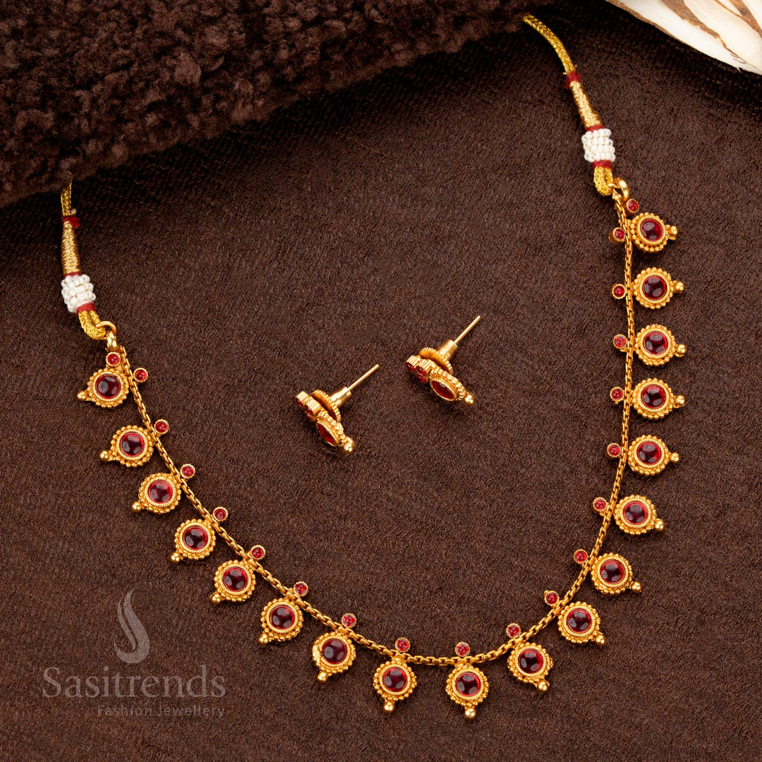 A timeless antique-style temple necklace set in matte gold, adorned with rich engravings, delicate droplet accents, and glowing ruby stones, bringing a regal aura to ethnic ensembles - Sasitrends