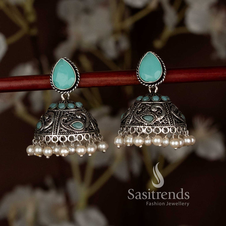 Charming sky-blue oxidised peacock motif teardrop stud jhumka earrings with pearl drops, designed for Navaratri party looks and elegant ethnic saree styling by Sasitrends