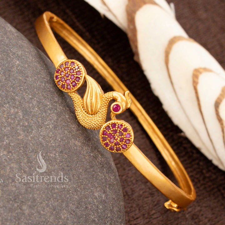A stunning openable gold plated peacock kada bracelet decorated with dazzling ruby American diamonds, adding elegance to ethnic jewellery collections - Sasitrends
