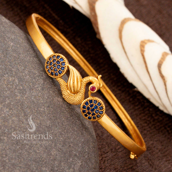 Regal openable gold plated peacock kada bracelet featuring striking blue American diamonds, adding grandeur to cultural jewellery collections - Sasitrends