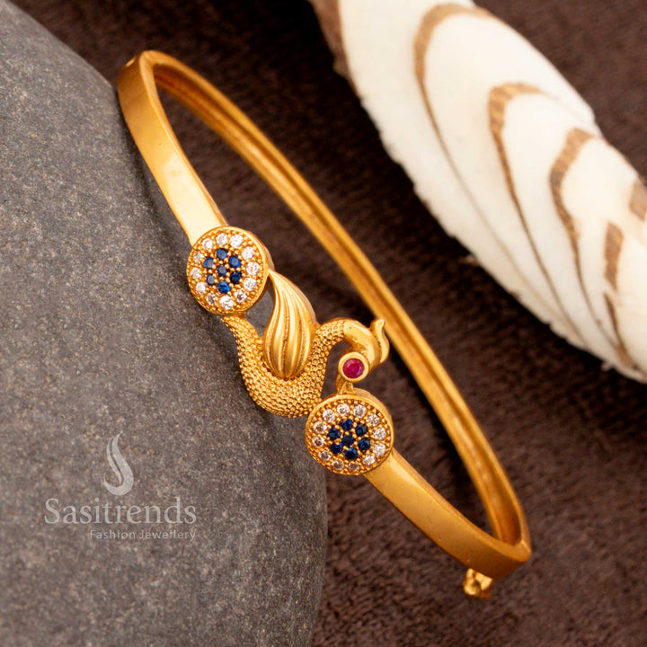 A glamorous openable gold plated peacock kada bracelet decorated with glittering white-blue American diamonds, radiating cultural jewellery excellence - Sasitrends