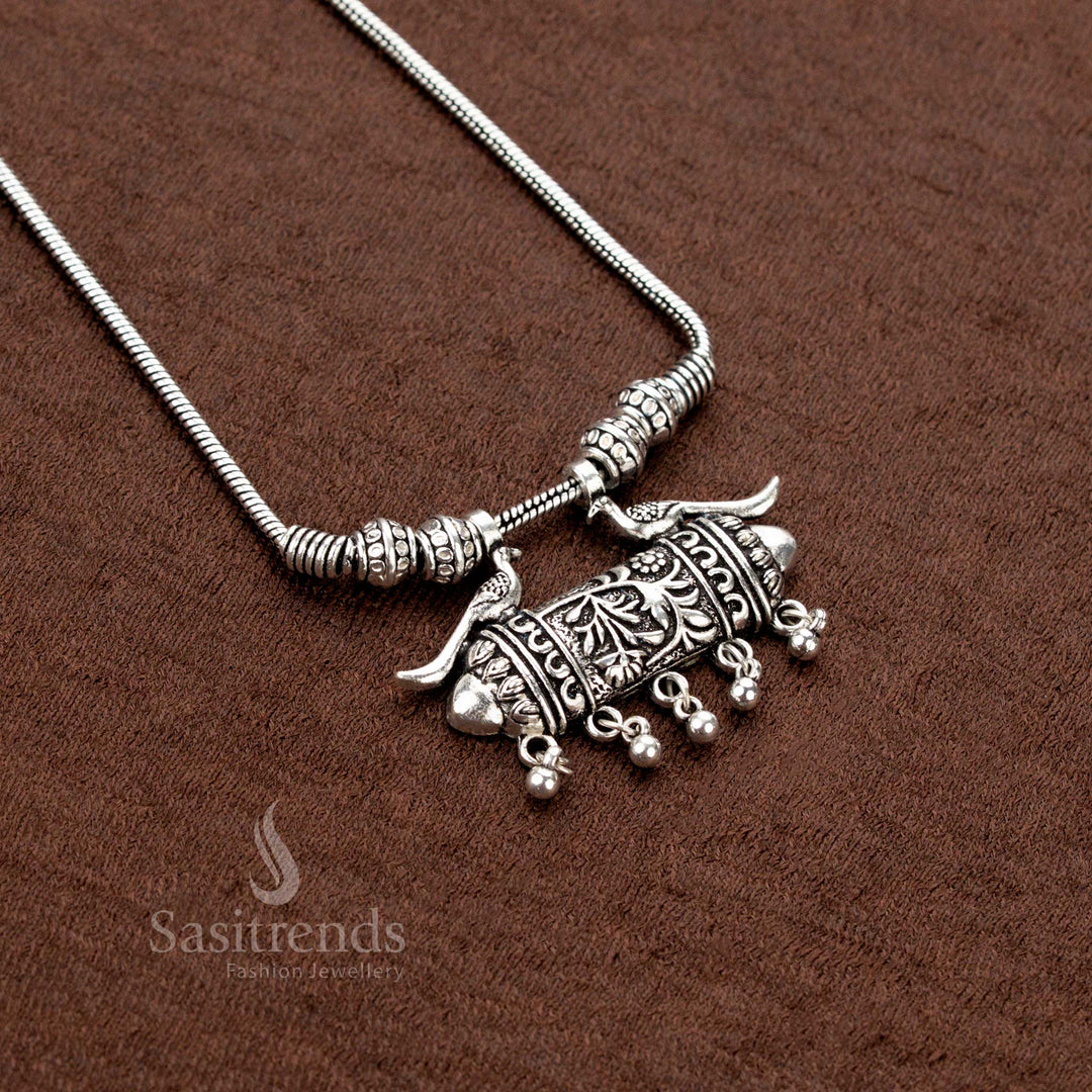 Timeless elegance radiates from this oxidised chain necklace featuring an engraved tribal-style tube pendant and a majestic peacock duo motif—an ethnic antique jewellery creation for cultural wear - Sasitrends