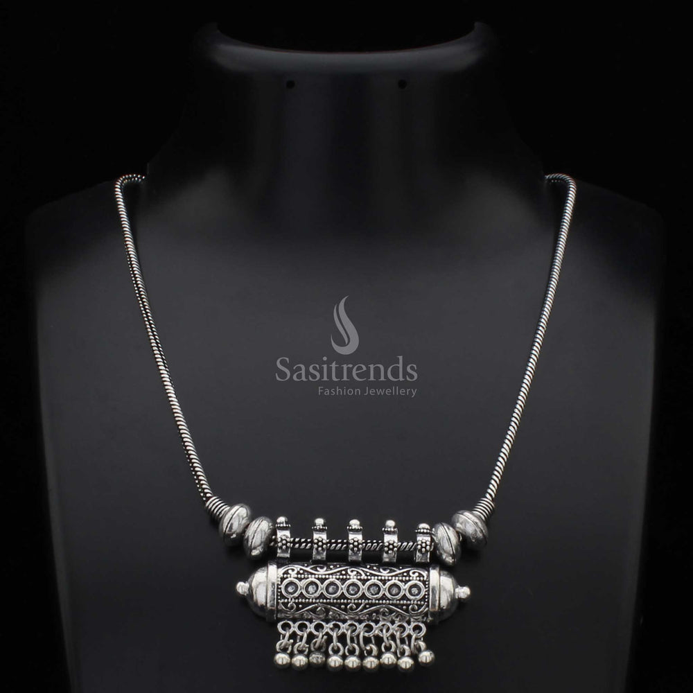 Traditional oxidised silver necklace with a cylindrical pendant and intricately carved antique ball drops – a cultural jewellery design rooted in tribal elegance, ideal for bohemian fashion and festive styling – Sasitrends