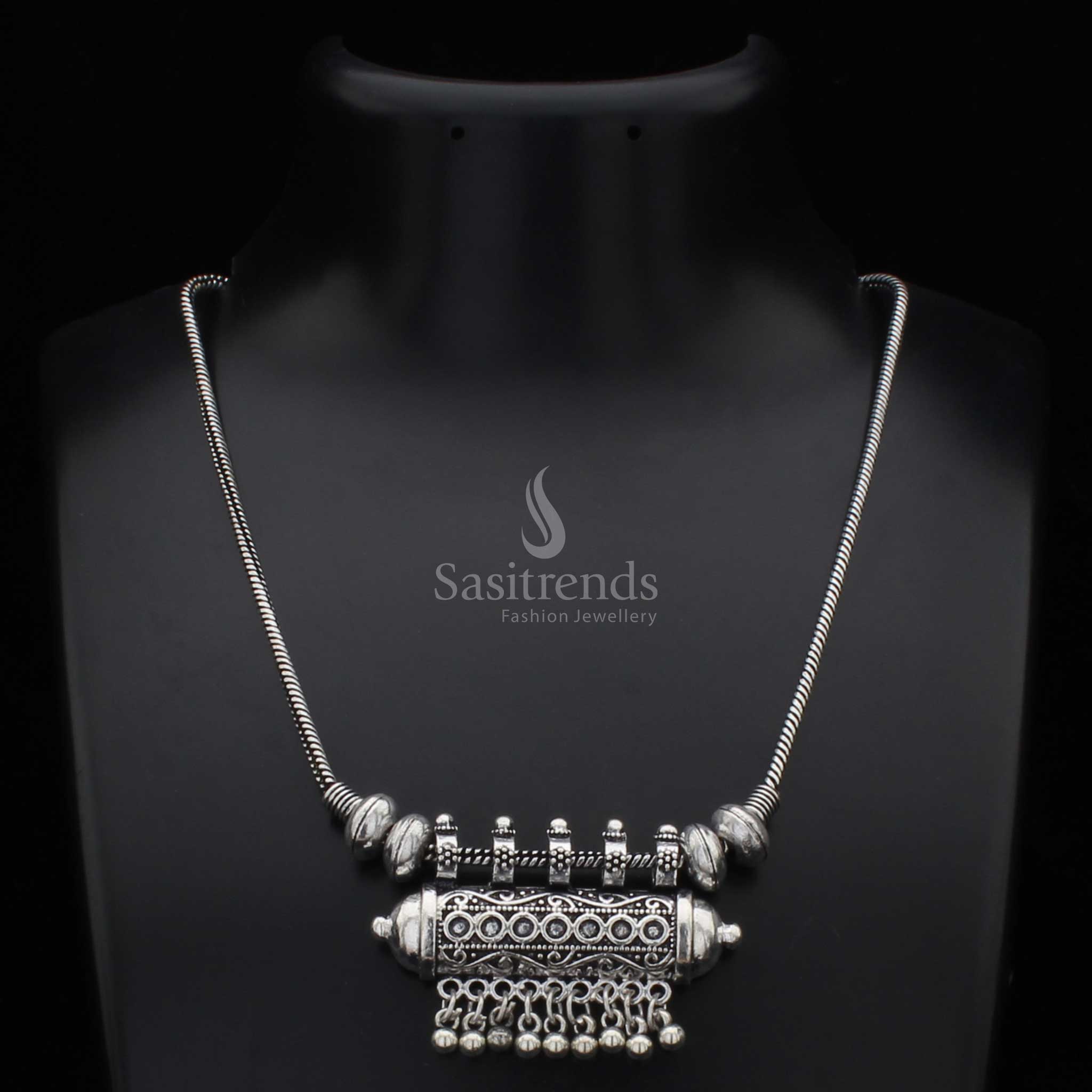 Traditional oxidised silver necklace with a cylindrical pendant and intricately carved antique ball drops – a cultural jewellery design rooted in tribal elegance, ideal for bohemian fashion and festive styling – Sasitrends