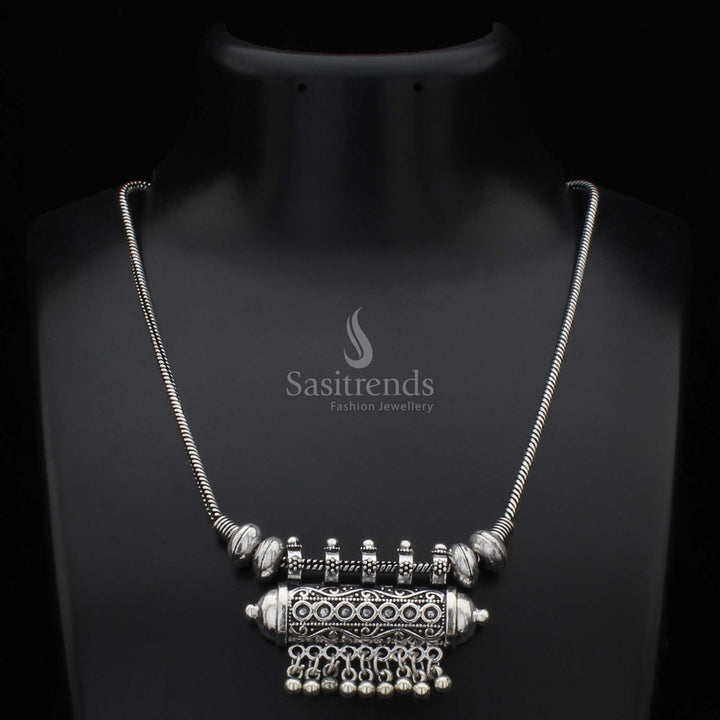 Traditional oxidised silver necklace with a cylindrical pendant and intricately carved antique ball drops – a cultural jewellery design rooted in tribal elegance, ideal for bohemian fashion and festive styling – Sasitrends
