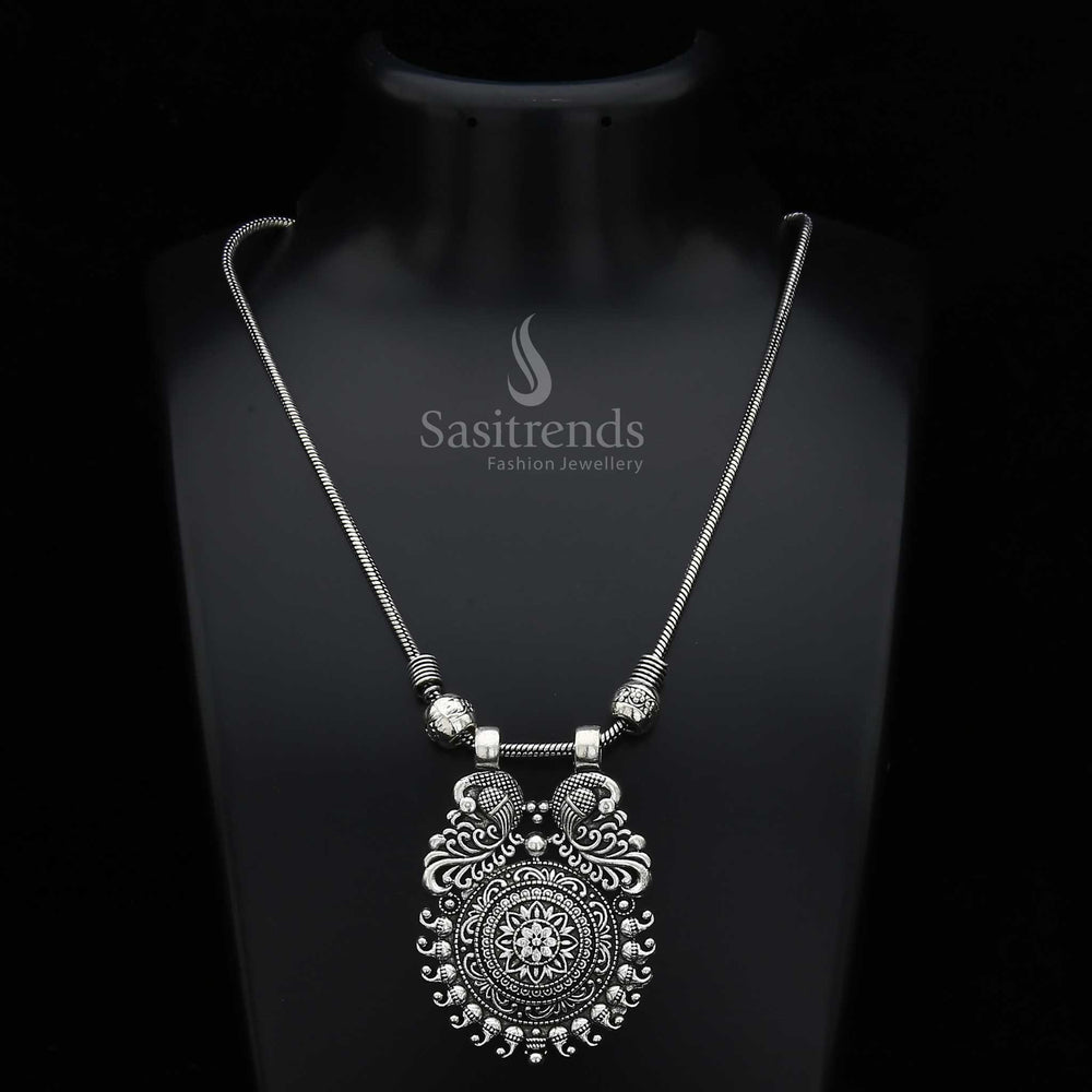 Enchanting Mayurika necklace featuring an oxidised silver and antique gold fusion pendant with majestic peacock, floral carvings, and mango motifs – a vibrant traditional jewellery treasure ideal for ethnic and festive occasions – Sasitrends