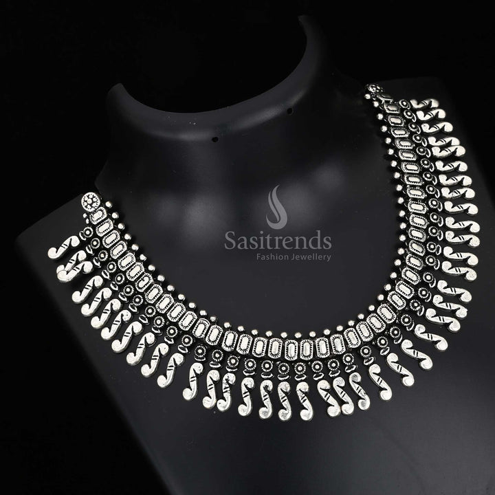 Enchanting roots in every carved detail – a Kolhapuri oxidised tribal necklace with bold central pendant and rustic charm drops, designed for folk jewellery elegance – Sasitrends