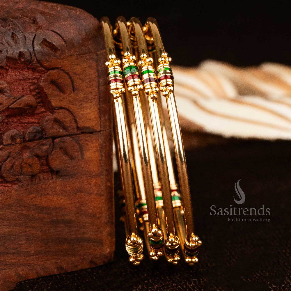 Bold traditional thin micro gold plated bangles pair with enamelled glow and rich red-green detailing, designed for a grand festive ethnic look with vibrant wrist presence – sasitrends