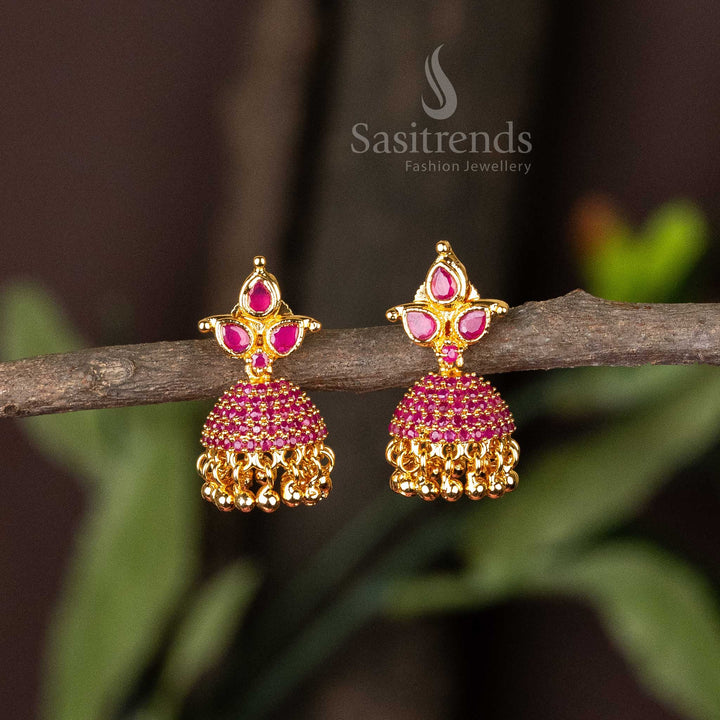 Ruby-hued classic Jhumka earrings in micro gold polish featuring petal-motif accents and American Diamonds – Traditional elegance for ethnic and bridal ensembles – Sasitrends