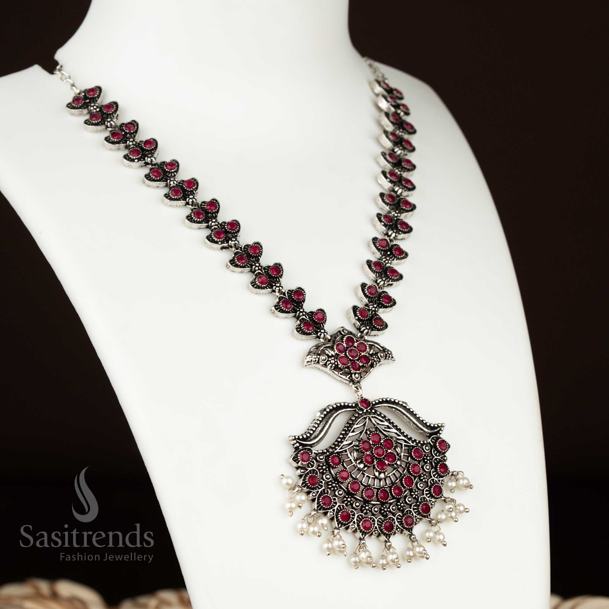Deep ruby oxidised silver party necklace with elegant flower design and pearl earrings – a vibrant and rich-toned jewellery piece for festive wear by sasitrends