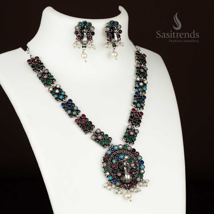 Multi-colour oxidised German silver necklace featuring a dancing peacock pendant with pearl drops and matching earrings – an ethnic glam jewellery set for festive wear by sasitrends