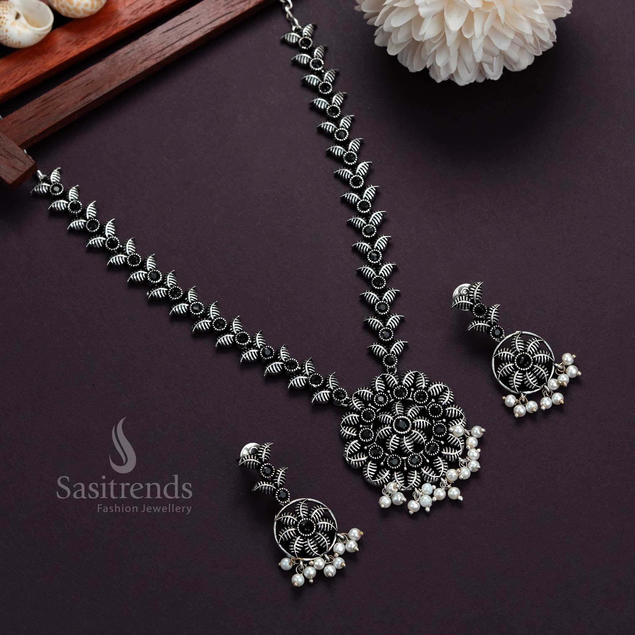 Trendy oxidised silver necklace with black flower-leaf pendant, pearl stones and matching earrings, perfect ethnic jewellery for traditional festivals and special occasions – Sasitrends