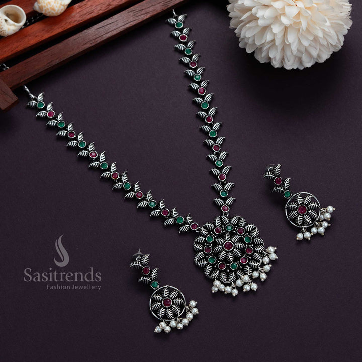 Fusion-style oxidised silver necklace in ruby-green stones with floral-leaf pendant and pearl earrings, a celebration-ready festive jewellery set – Sasitrends