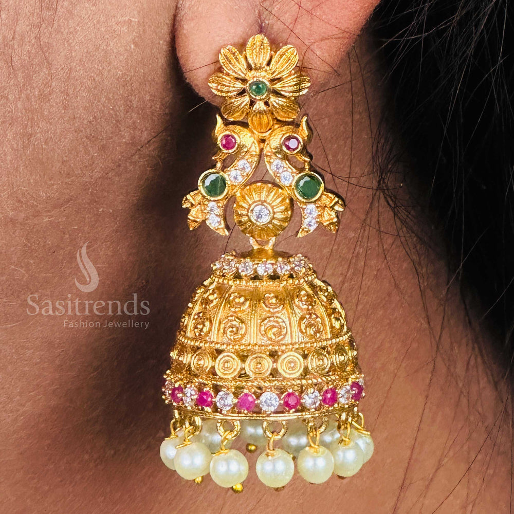 Vibrant temple jhumka earrings featuring peacock and floral designs in matte gold tone, multi-colour AD crystals and pearls creating a stunning blend of festive ethnic glamour by Sasitrends