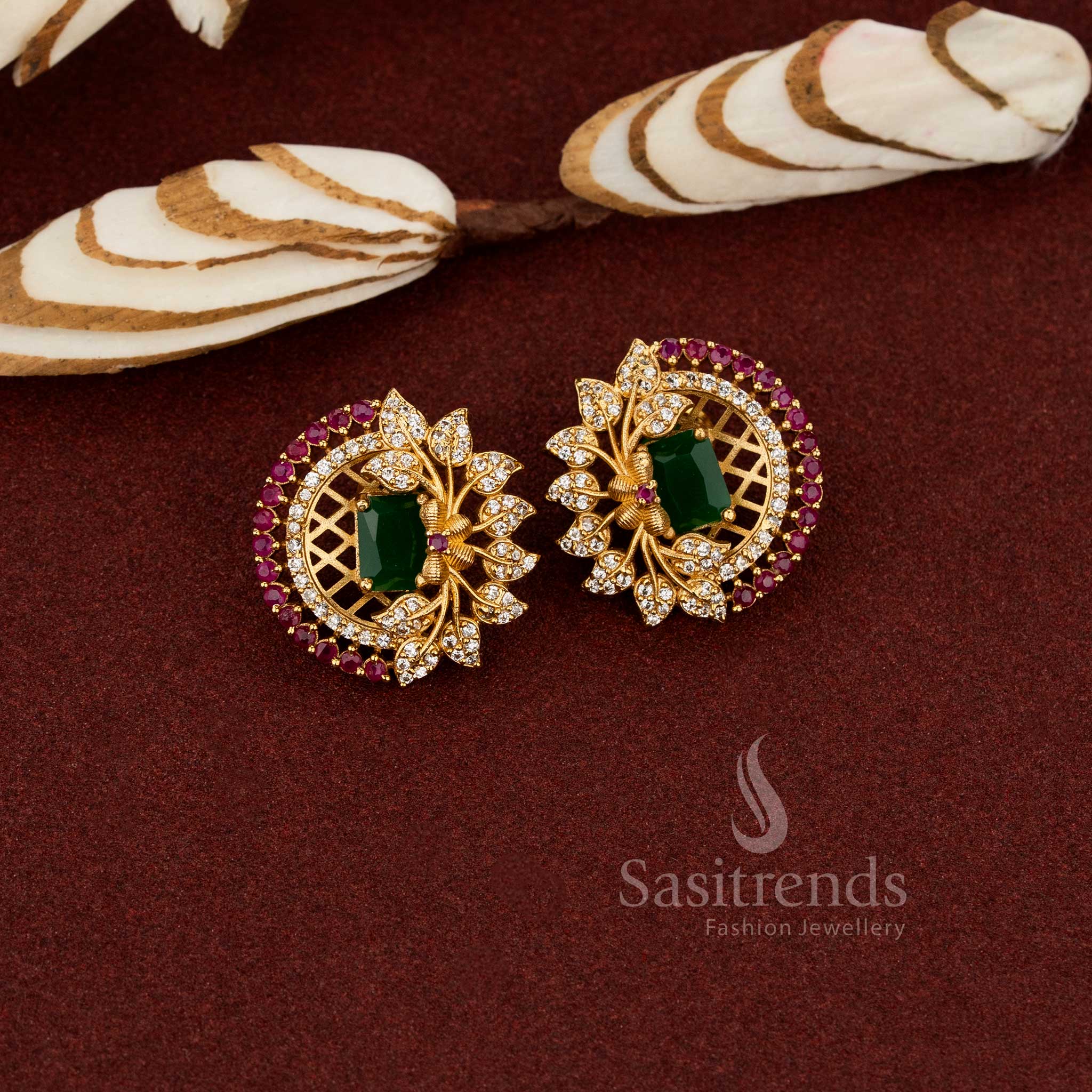 Ornate temple matte gold floral earrings with a centre green AD stone and intricate leaf pattern, crafted for a refined cultural jewellery look - Sasitrends