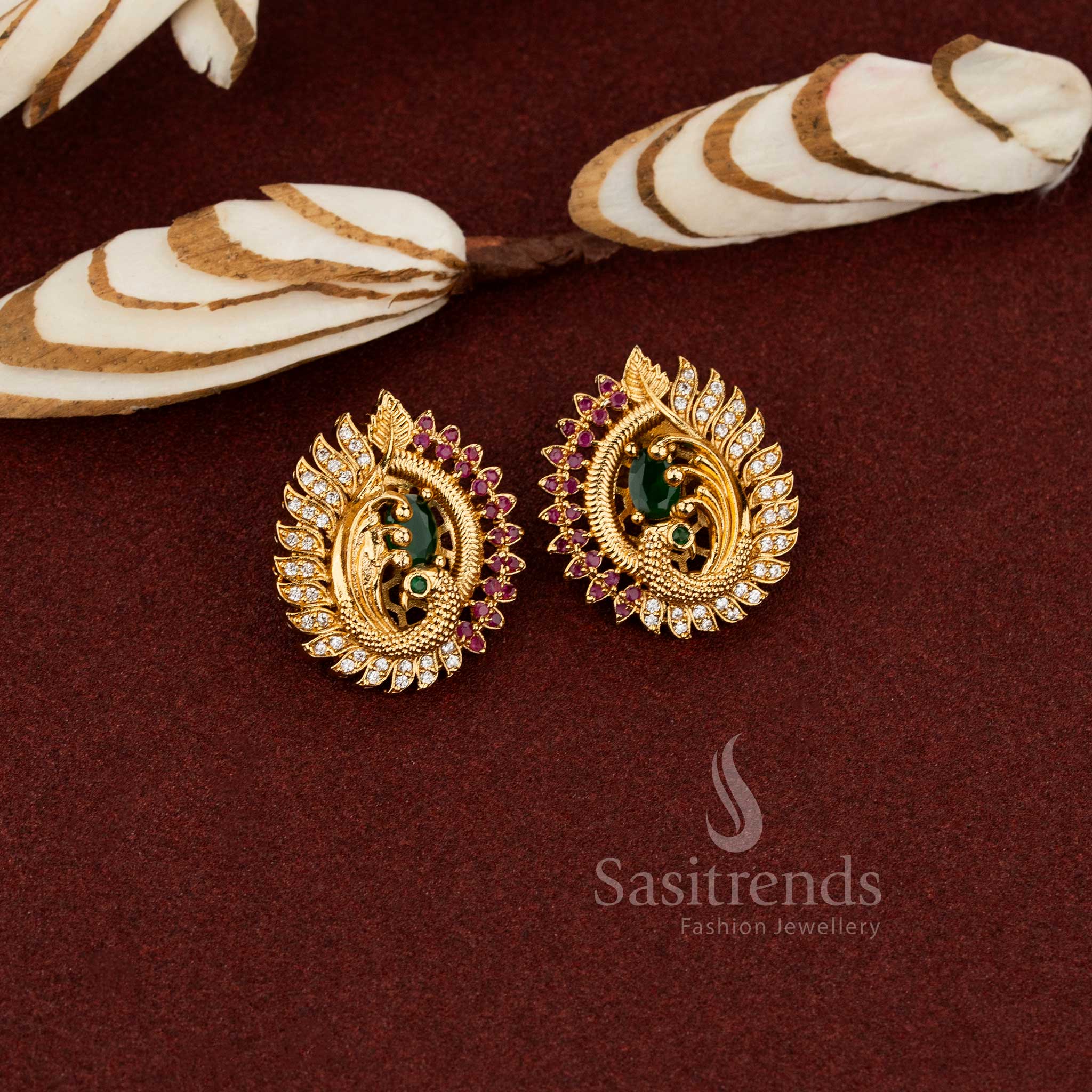 Ornate peacock face temple earrings with a centre green  AD stone in a matte gold tone, perfect for enhancing ethnic jewellery collections - Sasitrends