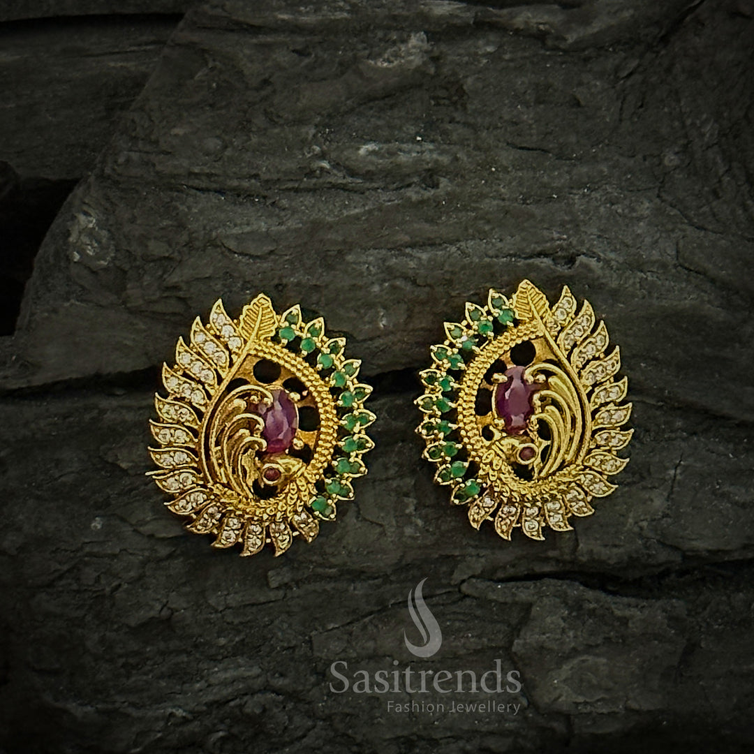Ornate peacock face temple earrings with a centre ruby AD stone in a matte gold tone, perfect for enhancing ethnic jewellery collections - Sasitrends