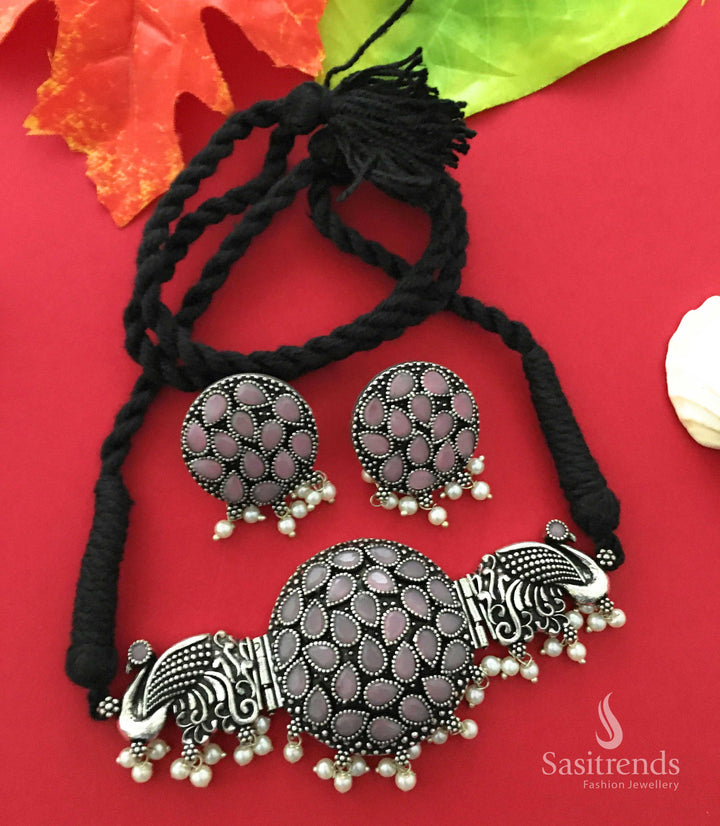 Blushing pink oxidised choker with intricate peacock pendant, stone work, and pearl earrings symbolising traditional romance – Jewellery from Sasitrends

