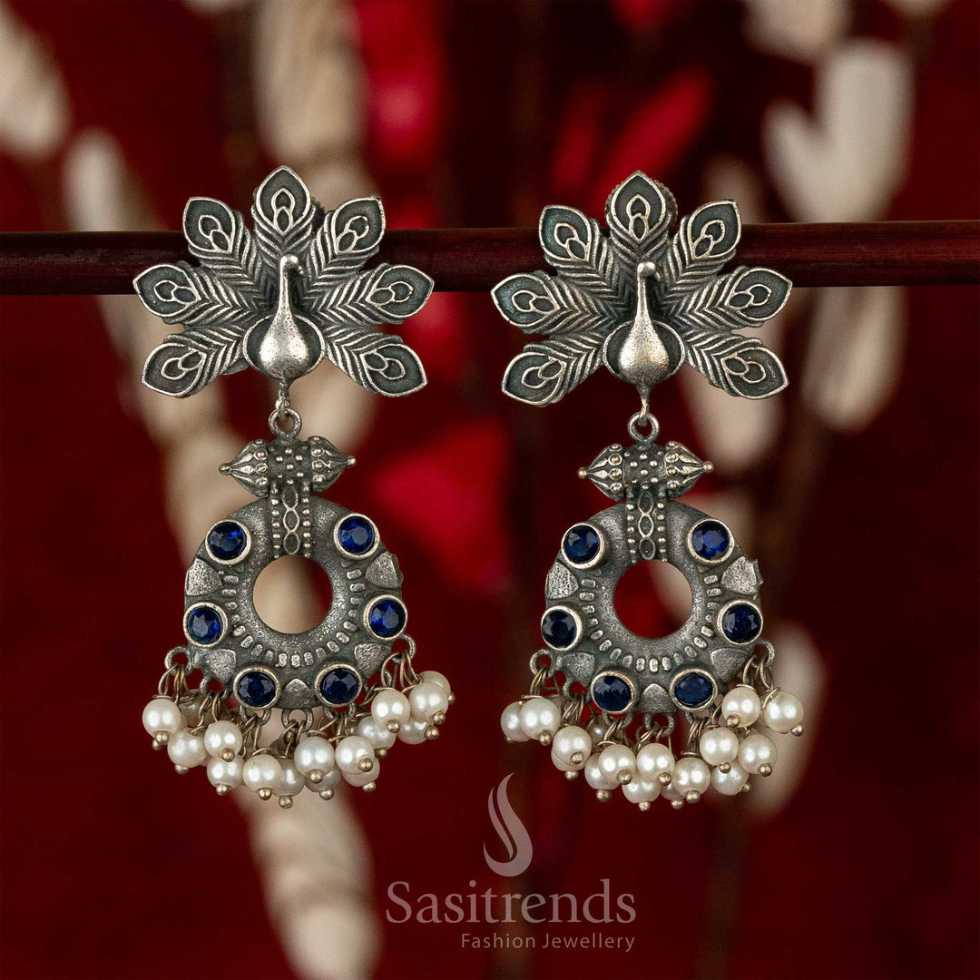 Elegant oxidised earrings with peacock motif, blue gemstone shimmer and pearl hangings – radiating earthy traditional jewellery elegance – Sasitrends